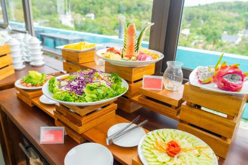 a buffet with plates of food on a table at Golden Daisy Hotel Phu Quoc in Phu Quoc