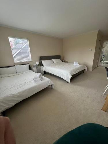 a bedroom with two beds and a window at Modern bedroom in Vancouver West in Vancouver
