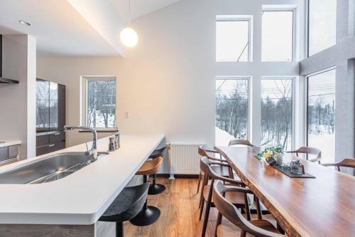 a kitchen with a sink and a wooden table at 翠葉 Rusutsu in Rusutsu