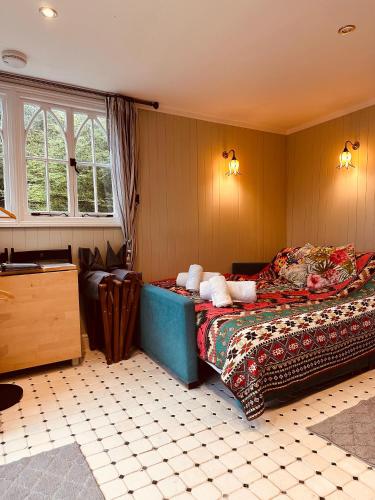 a bedroom with a bed and a couch in a room at The Little Fountain House in Dawlish