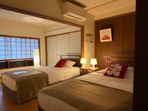 a hotel room with two beds and a window at KINO SPACE Kyoto in Kyoto
