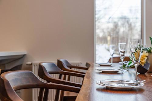 a long wooden table with chairs and wine glasses at 翠葉 Rusutsu in Rusutsu