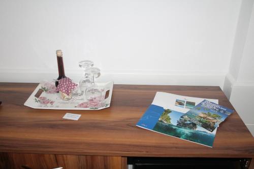 a wooden table with a book and a bottle of wine at Apartmens Villa Antonio 88 in Brela