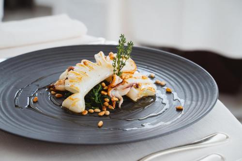 a black plate with a piece of food on a table at Hotel Cavalieri Palace & Suites in Lido di Jesolo