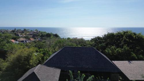 eine Luftaufnahme eines Hauses mit dem Meer im Hintergrund in der Unterkunft Serene Sunset Uluwatu in Uluwatu