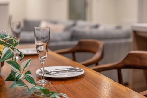 a wooden table with a wine glass and plates on it at 翠葉 Rusutsu in Rusutsu