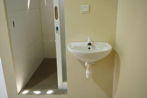 クタにあるAL-Q Hostel Kuta Lombokの洗面台とシャワー付きのバスルーム