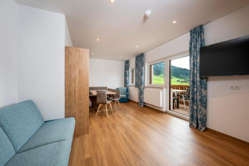a living room with a blue couch and a table at Aparthotel am Reitecksee in Flachau
