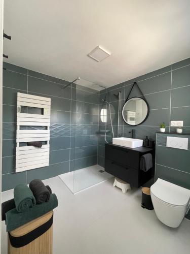 a bathroom with a sink and a toilet and a mirror at Maison du bonheur in Combres