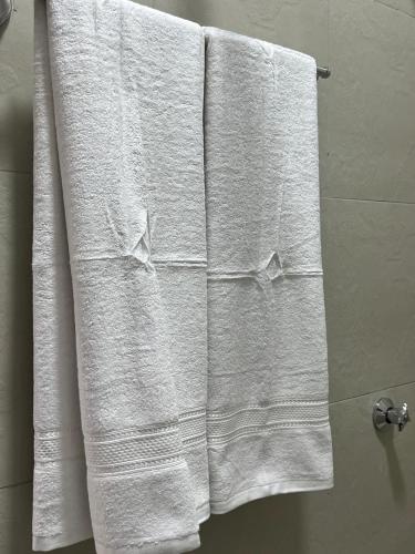 a group of white towels on a towel rack in a bathroom at Serenity Residences Studio Ruaka Near Two Rivers & UN Gigiri in Ruaka
