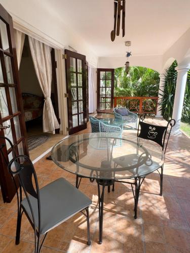 a living room with a glass table and chairs at Oistins 2BR Condo with Pool & Patio, Walk to Miami Beach in Christ Church