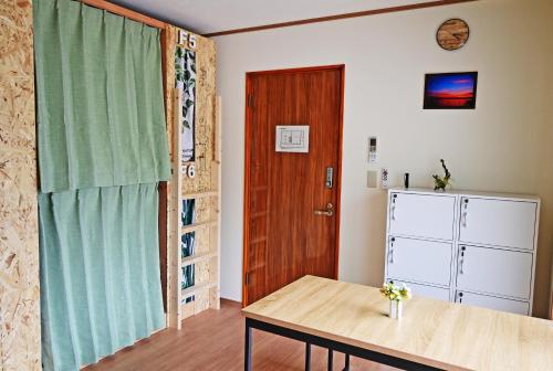 a room with a table and a wooden door at 鞆の浦ゲストハウス悠樂 Tomonoura Guest House You Raku in Fukuyama