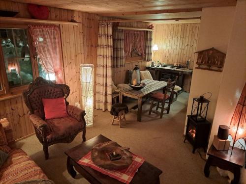 a living room with a table and a dining room at Chalet Chnorz Hosted in Nesslau