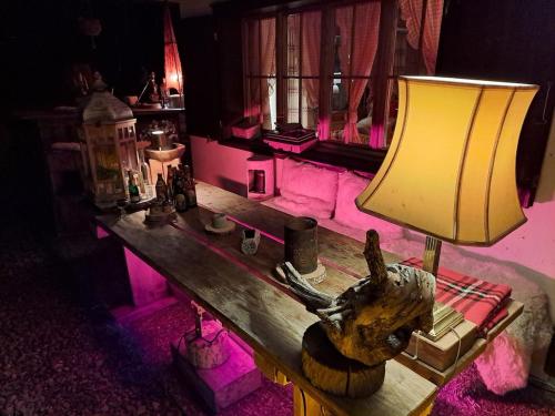 a room with a table with a lamp on it at Chalet Chnorz Hosted in Nesslau
