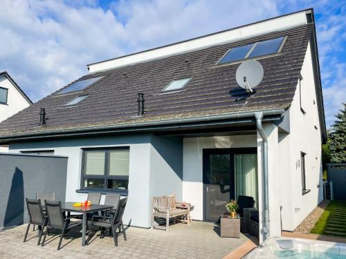 una casa con un patio con mesa y sillas en Ferien_VILLA BENVENUTI, en Göhren-Lebbin