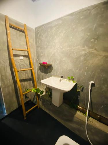 a bathroom with a white sink and a ladder at Ekamuthu Homestay in Dickwella