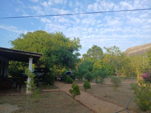 a view of a yard with trees and a house at Sigiri Arana Sigiriya in Sigiriya
