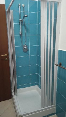 a bathroom with a shower with blue tiles at B&B Porta di Suso Camerota in Camerota