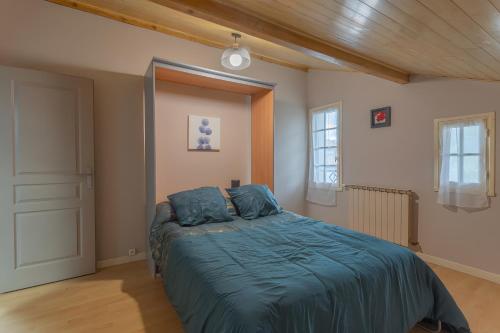 Un dormitorio con una cama con un edredón azul. en Maison Xara-heguia, en Hasparren