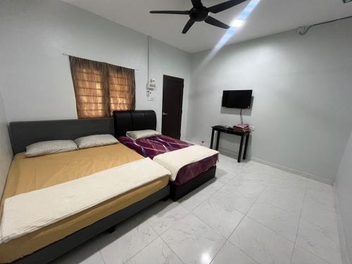 a bedroom with a bed and a ceiling fan at OYO 91220 D Inai Roomstay in Pantai Cenang