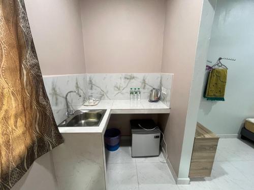 a small kitchen with a sink and a counter at OYO 91220 D Inai Roomstay in Pantai Cenang