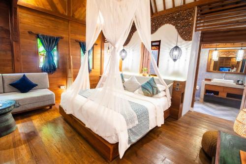 a bedroom with a bed with a mosquito net at Natya Hotel Tanah Lot in Tanah Lot