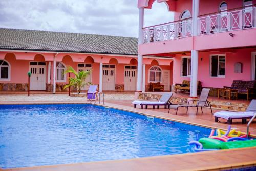 a villa with a swimming pool in front of a house at Villa Kidege in Accra