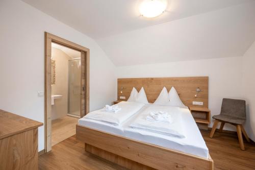 a bedroom with a bed with white sheets and a mirror at Aparthotel am Reitecksee in Flachau