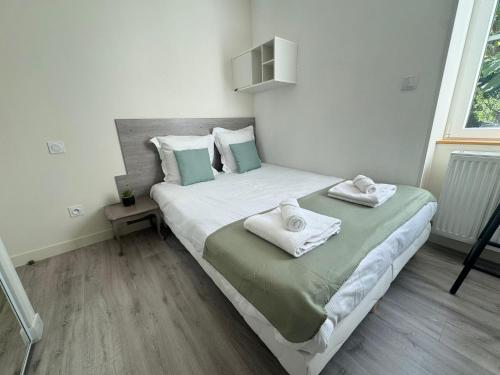 a bedroom with a bed with towels on it at Appartement - Parking Free - Hôtel Entre les 2 Roches in Prissé