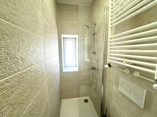 a bathroom with a shower and a toilet and a window at Appartement - Parking Free - Hôtel Entre les 2 Roches in Prissé