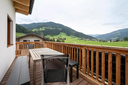 a wooden deck with a table and chairs on a balcony at Aparthotel am Reitecksee in Flachau