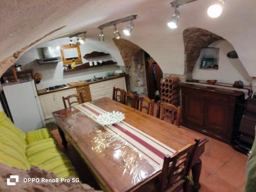 Una cocina y un comedor con una mesa de madera. en La Dimora in Pietra, en Montenero Val Cocchiara