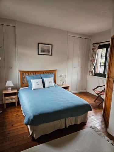 a bedroom with a blue bed with two pillows at Maison normande au cœur de Le Bec-Hellouin in Le Bec-Hellouin