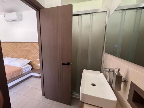 a bathroom with a sink and a toilet and a bed at Onda Resort Pacifico in San Isidro