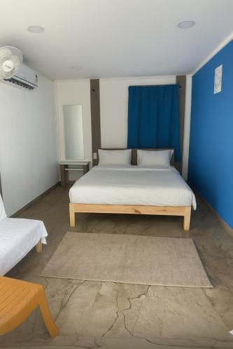 a bedroom with a bed and a blue wall at Stay NC Eco Cottages in Nashik