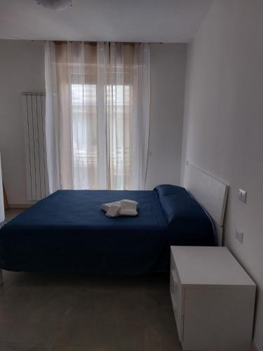 a bedroom with a blue bed and a window at Il Colle in Azzano Mella