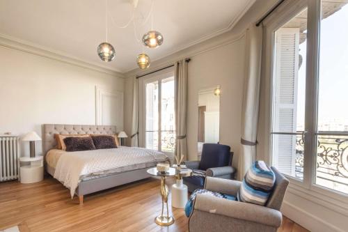 une chambre avec un lit, une table et des chaises dans l'établissement Luxury Flat Eiffel View 3BR 7 Guests, à Paris
