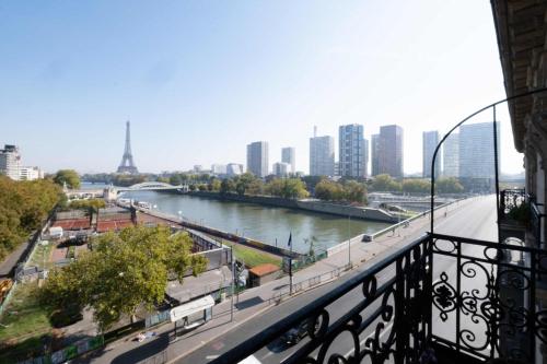 une vue sur une rivière avec une ville en arrière-plan dans l'établissement Luxury Flat Eiffel View 3BR 7 Guests, à Paris