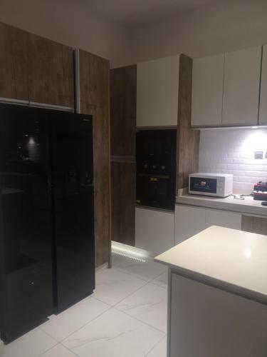 a kitchen with a black refrigerator and a microwave at David Akpo in Lekki