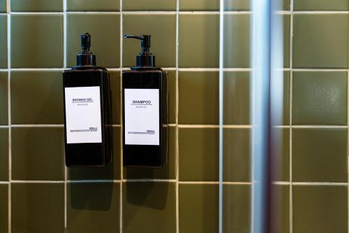 two bottles of soap in a tiled bathroom at Azurara Guesthouse in Azurara