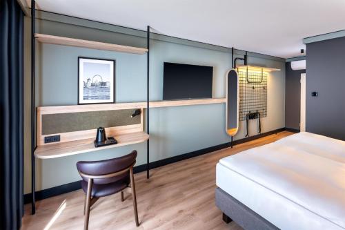 a bedroom with a bed and a desk and a chair at Radisson Hotel Düsseldorf City Center in Düsseldorf