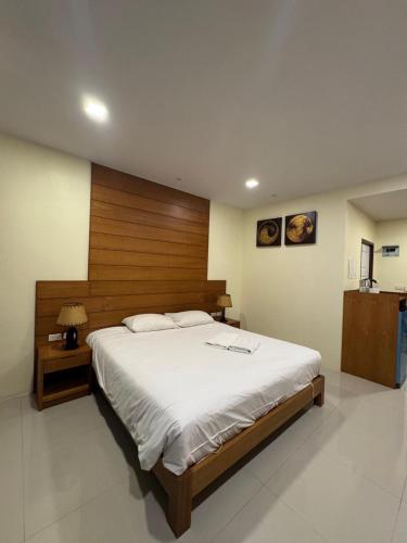 a bedroom with a large bed with a wooden headboard at Baan Phu Chalong Place in Ban Suan