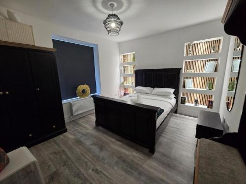 a bedroom with a large bed and a large window at Stylish 6-Bedroom House, Town Centre, Sleeps 14, With Garden in Merthyr Tydfil