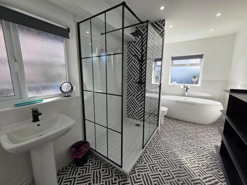 a bathroom with a shower and a sink and a tub at Stylish 6-Bedroom House, Town Centre, Sleeps 14, With Garden in Merthyr Tydfil