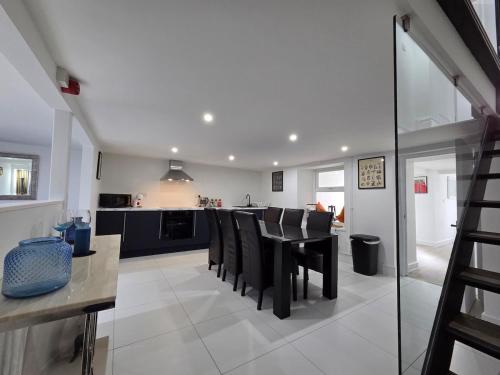 a kitchen and dining room with a table and chairs at Stylish 6-Bedroom House, Town Centre, Sleeps 14, With Garden in Merthyr Tydfil
