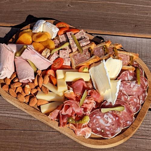 a pizza with different types of food on a wooden table at La Suite in Chiroubles