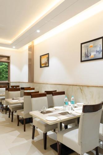 a dining room with white tables and chairs at Dahabi Era -FREE Pickup or Airport Drop in New Delhi