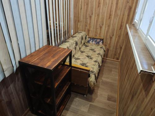 a small couch in a room with a table at Квартира 1 комнатная in Aktau