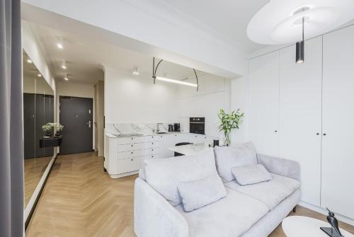 Il comprend un salon blanc avec un canapé et une cuisine. dans l'établissement Premium Sky - Apartament przy Enea Stadion Poznań, à Poznań