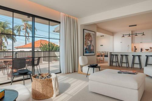 a living room with a white couch and a kitchen at Villa Mangoni - Brand New Luxury Villa in Funchal